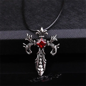 Dettaglio della collana croce gotica in argento con gemma rossa e rilievo a vite