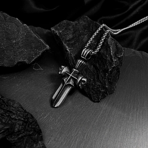 Detail of gothic dagger pendant with skull and cross on retro pearl chain necklace