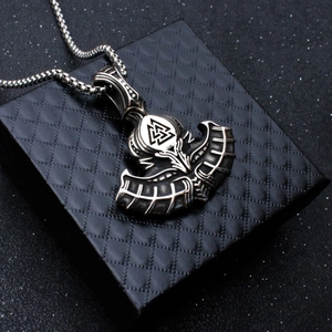 Détail du pendentif hache Viking avec symbole Valknut sur un écrin à bijoux noir texturé