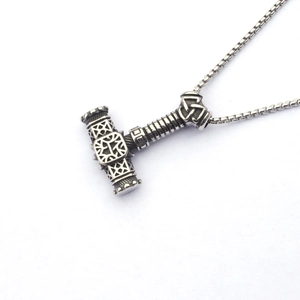 Gros plan du pendentif Mjölnir en argent vieilli avec motifs de nœuds celtiques