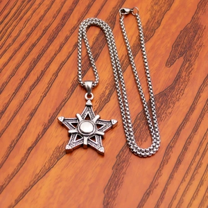 Macro-opname van industriële pentagram-hanger van zilver roestvrij staal op houtnerf