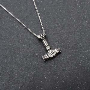 Détail macro du pendentif Marteau de Thor Mjölnir avec nœuds celtiques et gravure