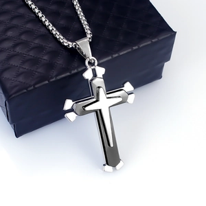 Close-up of double layer stainless steel cross pendant on a black gift box