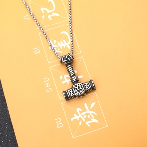 Vue détaillée du pendentif Mjölnir avec runes nordiques sur une chaîne en acier inoxydable