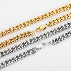 Detailed view of gold and silver cuban link chains with secure lobster clasps on white