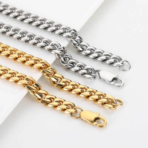 Close-up of polished gold and silver Cuban link chains with large lobster clasps