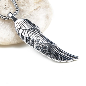 Detailed close-up of a silver wing pendant showing intricate feather texture and aging