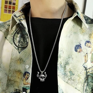 Macro detail of a punk-style bull skull pendant on a heavy stainless steel chain necklace