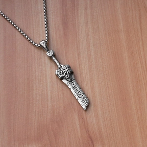 Détail macro du pendentif épée ancienne avec gravures de runes et finition argentée vintage