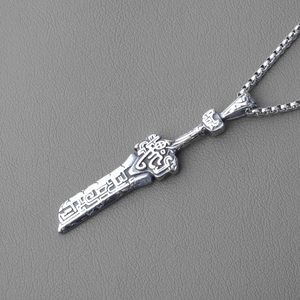 Vue macro du pendentif épée vintage en acier inoxydable avec relief gravé et fini oxydé