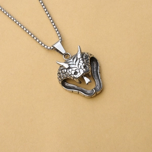 Detail of vintage cobra pendant showing intricate stainless steel scale carvings and square chain