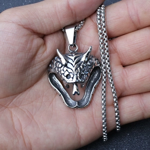Detailed macro view of the cobra head pendant with vintage scale textures on a steel chain