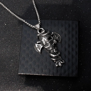 Gothic punk necklace featuring silver skull snake and battle axe pendant on black jewelry box