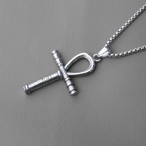 Détail macro du pendentif croix Ankh en argent vintage avec texture vieillie sur cuir