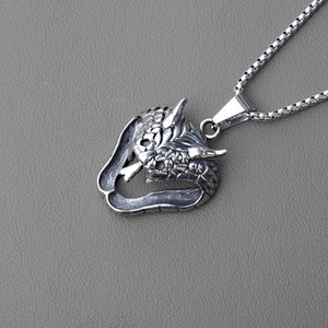 Macro shot of cobra head pendant featuring detailed scales and vintage oxidized steel texture