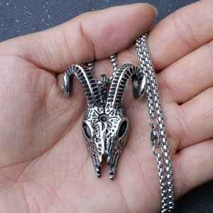 Gothic ram skull pendant necklace in vintage stainless steel on a person's palm