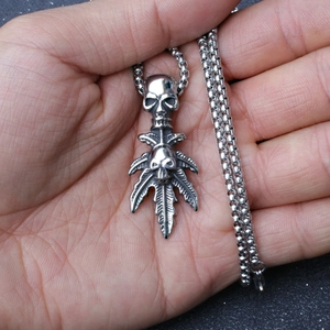 Gothic punk necklace featuring stacked skulls and maple leaf pendant on a box chain
