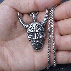 Détail macro du pendentif masque Prajna gothique sur chaîne de boîte dans la main