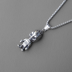 Detail of silver devil alien pendant with star of david on gray leather background