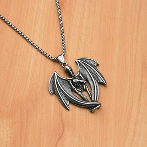 Detail shot of punk gothic skull pendant with bat wings on a vintage metal chain