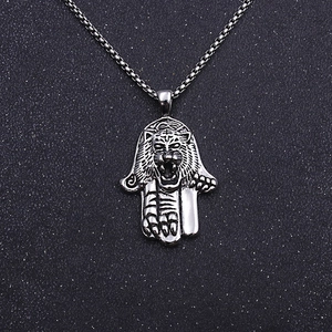 Macro shot of vintage silver Hamsa hand pendant with embossed tiger head and claw