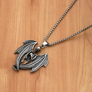 Gothic skull with bat wings pendant detail on vintage box chain over wood background