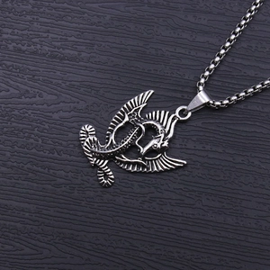 Dettaglio di un ciondolo a forma di drago vintage in argento con catena box testurizzata