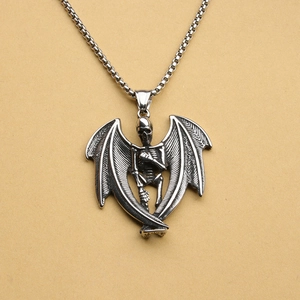Detailed close-up of a silver skull pendant with wings on a square link chain
