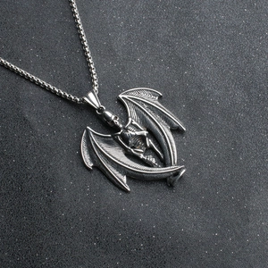 Macro detail of a gothic punk skeleton pendant with intricate bat wings on box chain
