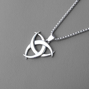 Detail of Celtic trinity knot pendant with polished box chain on grey leather