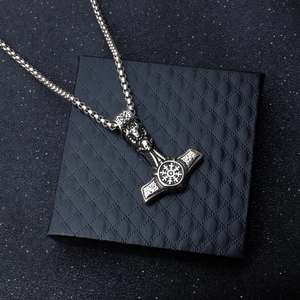 Macro shot of Viking Mjolnir pendant with Nordic runes on a black jewelry box
