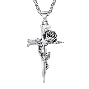 Macro detail of gothic cross pendant with rose vine and vintage stainless steel finish