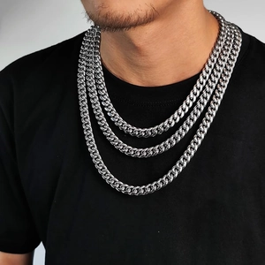Three-layer stack of silver stainless steel Cuban link necklaces on a model