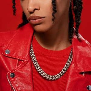 Close-up of thick silver Cuban link necklace on model wearing a red leather jacket