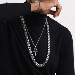 Detailed view of silver stainless steel Cuban link chain and Ankh cross pendant on model