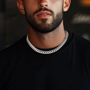 Close-up of polished silver stainless steel Cuban link chain on male model neck