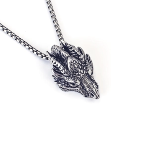 Macro detail of retro dragon head pendant in antique silver finish with box chain