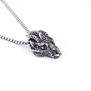 Close-up of vintage silver dragon head pendant with box chain on a clean white background