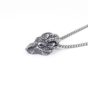 Detailed macro shot of a gothic retro dragon head pendant in vintage silver steel