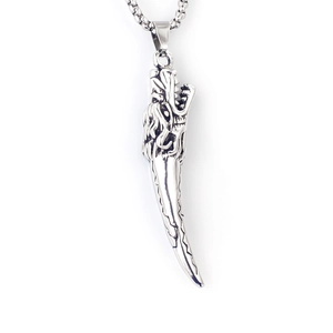 Détail d'un pendentif dent de loup en acier vintage avec tête de dragon et chaîne
