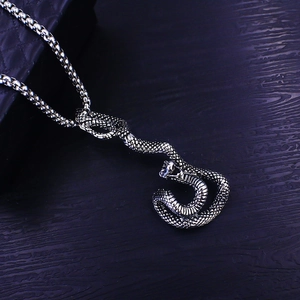 Macro detail of retro snake pendant necklace with vintage silver scales and thick box chain