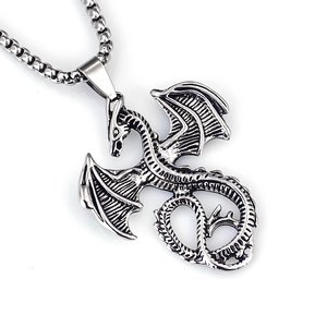 Detailed close-up of a vintage stainless steel dragon pendant with intricate wing scales