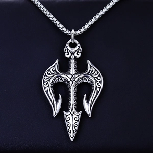 Macro shot of trident pendant featuring vintage vine patterns on black leather background