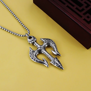 Macro detail of retro stainless steel trident pendant with intricate carved wave patterns