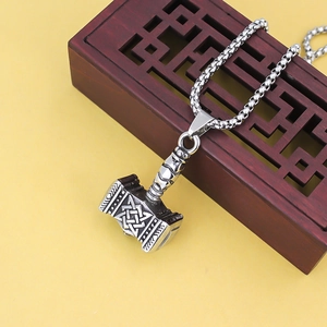 Vintage stainless steel Mjolnir pendant necklace with Celtic knot patterns on yellow background