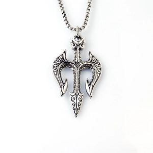 Detailed close-up of trident anchor pendant with vintage scroll engravings and steel chain