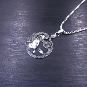 Detailed macro of vintage Medusa pendant with snakes on a rustic wood background