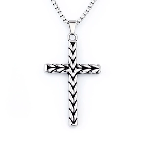 Macro detail of stainless steel cross pendant with woven texture on silver box chain