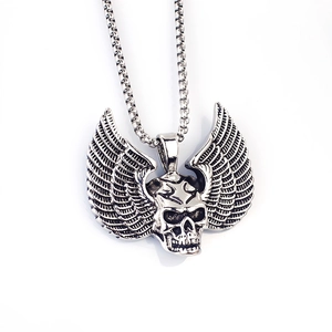 Detailopname van een zilveren punk schedelhanger met vleugels en vintage afwerking