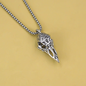 Close-up of gothic stainless steel bird skull pendant with intricate vintage carvings